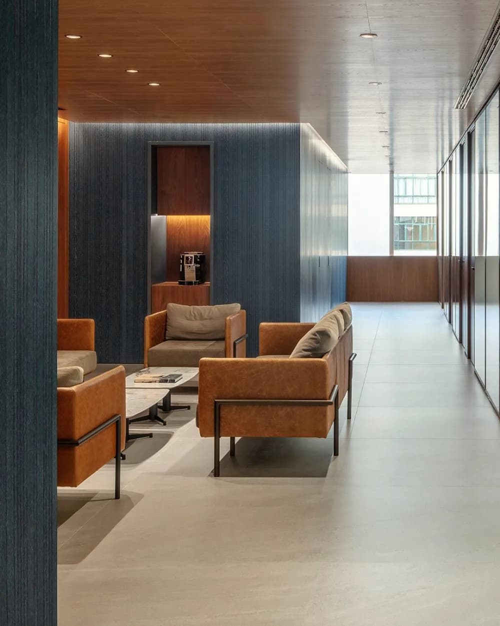 Two leather chairs beside a floor to ceiling fluted wall.
