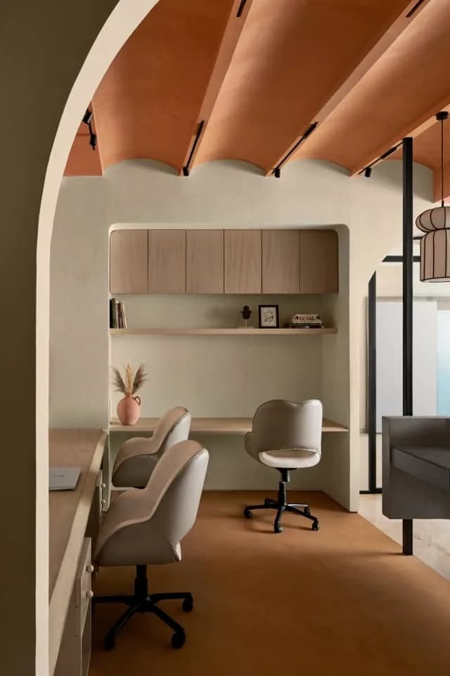 Arched brick vault over built in cabinets and two chairs.
